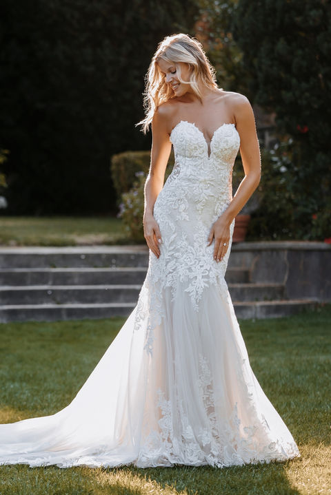 outdoor photo of woman wearing white allure couture designer wedding dress
