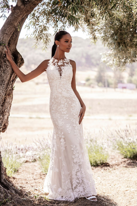 outdoor photo of woman wearing white allure romance designer wedding dress