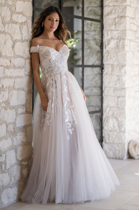 outdoor photo of woman wearing white allure romance designer wedding dress