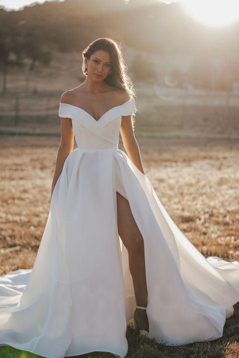 outdoor photo of woman wearing white allure romance designer wedding dress