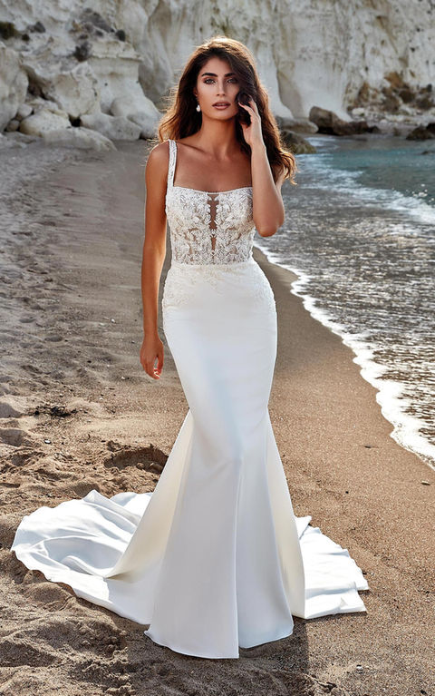beach photo of woman wearing white designer eddy k wedding dress