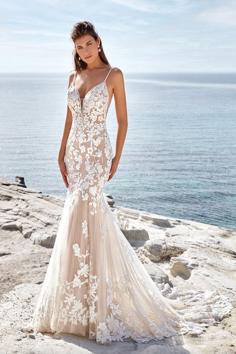 beach photo of woman wearing white designer eddy k wedding dress
