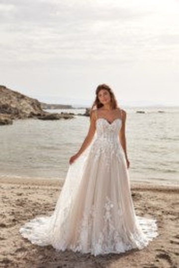 outdoor photo of woman wearing white designer eddy k wedding dress