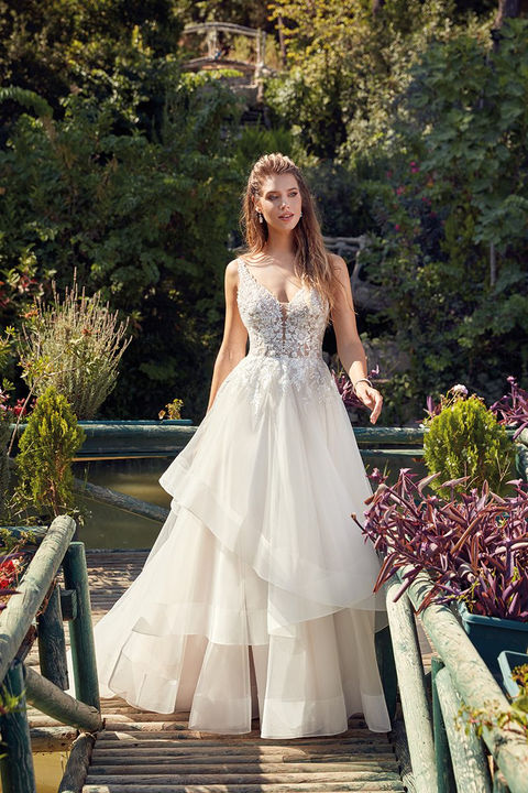 outdoor photo of woman wearing white designer eddy k wedding dress