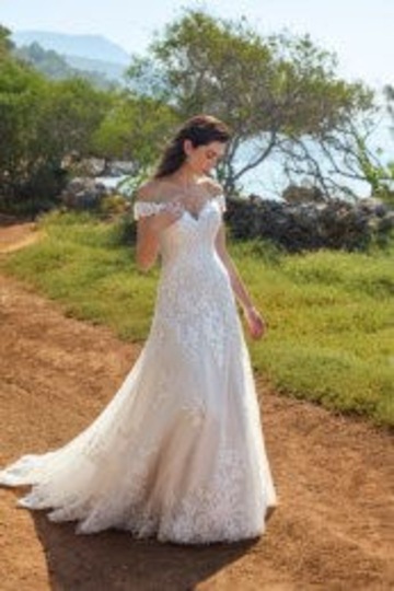 outdoor photo of woman wearing white designer eddy k wedding dress