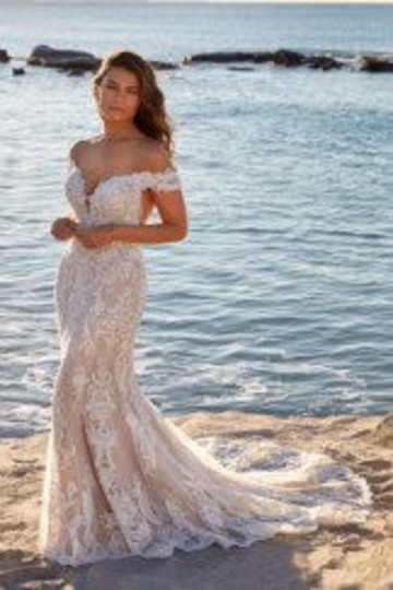 beach photo of woman wearing white designer eddy k wedding dress