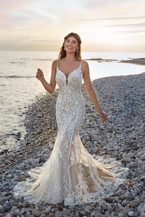 beach photo of woman wearing white designer eddy k wedding dress