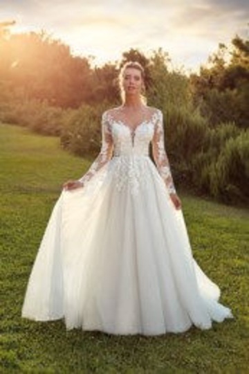 outdoor photo of woman wearing white designer eddy k wedding dress