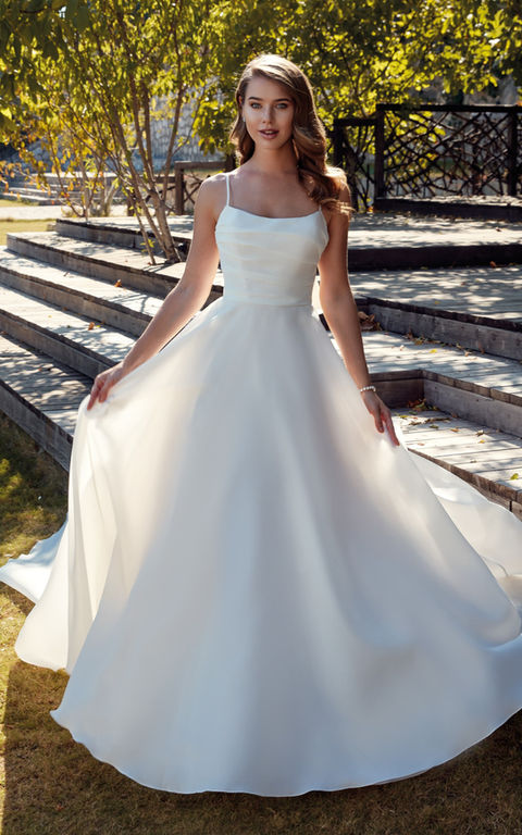 outdoor photo of woman wearing white designer eddy k wedding dress