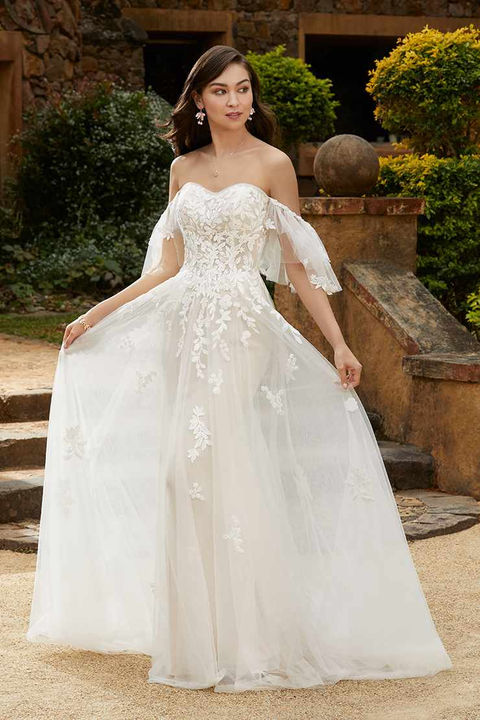 outdoor photo of woman wearing white designer sophia tolli wedding dress