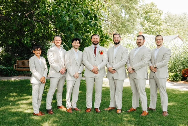 groom and groomsmen standing for photo outdoors